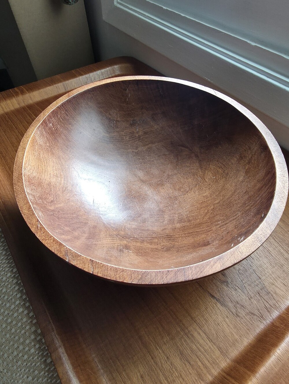 Hand-turned wooden serving bowl, rich dark finish, softly oval, organic Shape.